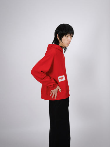 Unisex red hoodie with embroidered white patch featuring a running horse – premium designer sportswear by GRIT that blends performance and elevated streetwear fashion
